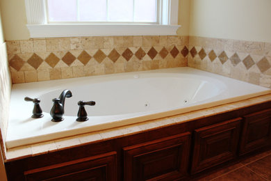 Example of a master drop-in bathtub design in Atlanta with beige walls