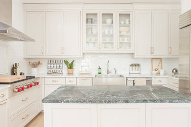 Eat-in kitchen - mid-sized transitional u-shaped light wood floor and brown floor eat-in kitchen idea in Philadelphia with a farmhouse sink, recessed-panel cabinets, gray cabinets, marble countertops, white backsplash, subway tile backsplash, stainless steel appliances, an island and white countertops