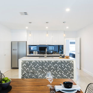 Mid-sized contemporary kitchen pantry designs - Kitchen pantry - mid-sized contemporary single-wall ceramic floor and beige floor kitchen pantry idea in Canberra - Queanbeyan with a drop-in sink, white cabinets, solid surface countertops, metallic backsplash, mirror backsplash, stainless steel appliances and an island