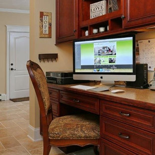 Inspiration för små amerikanska hemmabibliotek, med beige väggar, travertin golv och ett inbyggt skrivbord