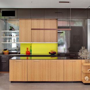 Contemporary open plan kitchen in Sydney with a single-bowl sink, flat-panel cabinets, light wood cabinets, green splashback, concrete floors, with island, grey floor and brown benchtop.