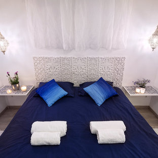 Foto di una piccola camera da letto etnica con pareti bianche, pavimento in laminato e pavimento beige