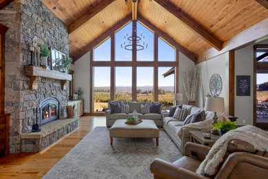 Photo of an expansive classic open plan living room in Portland with beige walls, medium hardwood flooring, a standard fireplace, a stone fireplace surround, a built-in media unit and a vaulted ceiling.