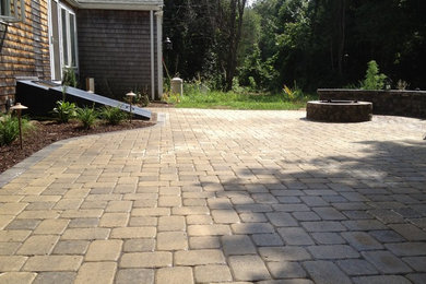 Example of a classic backyard patio design in Providence with a fire pit
