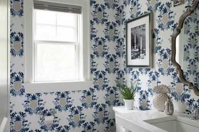 Powder room - transitional gray floor powder room idea in New York with open cabinets, white cabinets, a two-piece toilet, multicolored walls, an undermount sink and white countertops