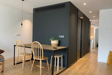 Diseño de comedor minimalista grande abierto con paredes negras, suelo de madera en tonos medios y suelo marrón