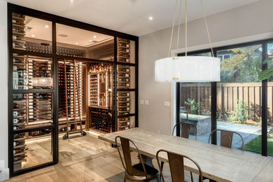 Example of a small farmhouse light wood floor and beige floor wine cellar design in Portland with display racks