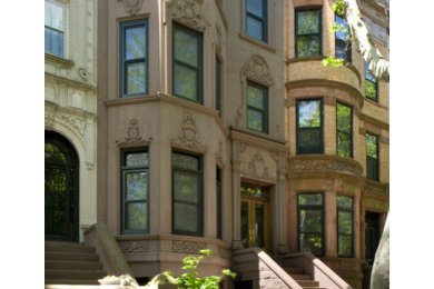 Large elegant beige three-story stucco exterior home photo in New York with a shingle roof