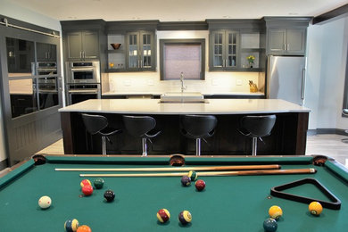 Example of a transitional single-wall marble floor and white floor open concept kitchen design in Other with a farmhouse sink, beaded inset cabinets, gray cabinets, quartz countertops, white backsplash, subway tile backsplash, stainless steel appliances and an island