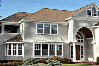 Large traditional beige three-story wood house exterior idea in Boston with a gambrel roof and a shingle roof