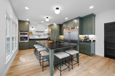 Inspiration for a large transitional vinyl floor and beige floor eat-in kitchen remodel in Atlanta with an integrated sink, shaker cabinets, green cabinets, granite countertops, yellow backsplash, marble backsplash, stainless steel appliances, an island and black countertops