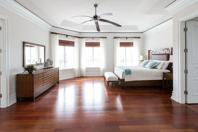 This is an example of a large modern master bedroom in New York with white walls and dark hardwood floors.