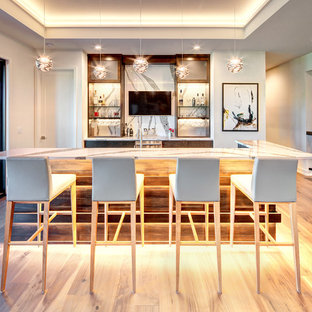 ダラスのコンテンポラリースタイルのおしゃれな着席型バー (フラットパネル扉のキャビネット、濃色木目調キャビネット、白いキッチンパネル、淡色無垢フローリング、ベージュの床、白いキッチンカウンター) の写真