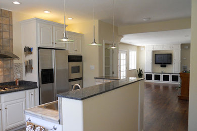 Example of a mid-sized single-wall dark wood floor kitchen design in San Francisco with beaded inset cabinets, white cabinets, granite countertops and an island