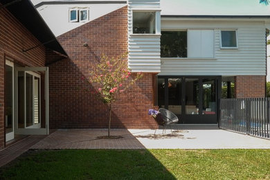 Design ideas for a mid-sized contemporary home design in Brisbane.