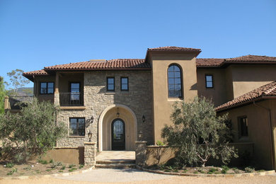 Inspiration for a large mediterranean beige two-story mixed siding exterior home remodel in Santa Barbara with a hip roof