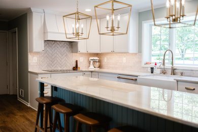 Example of a large classic l-shaped medium tone wood floor and brown floor eat-in kitchen design in Baltimore with a farmhouse sink, shaker cabinets, white cabinets, recycled glass countertops, white backsplash, porcelain backsplash, white appliances, an island and gray countertops
