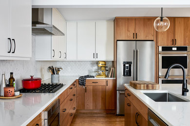 Mid-sized transitional l-shaped medium tone wood floor eat-in kitchen photo in DC Metro with white backsplash, stainless steel appliances, an island and white countertops