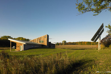 Large contemporary two-story wood exterior home idea in New York with a shed roof