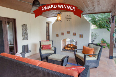 Patio - southwestern backyard patio idea in Phoenix with a fireplace and a roof extension