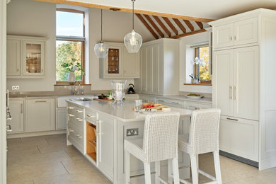 Photo of a medium sized traditional u-shaped open plan kitchen in Buckinghamshire with a belfast sink, shaker cabinets, grey cabinets, engineered stone countertops, grey splashback, engineered quartz splashback, stainless steel appliances, porcelain flooring, an island and grey worktops.