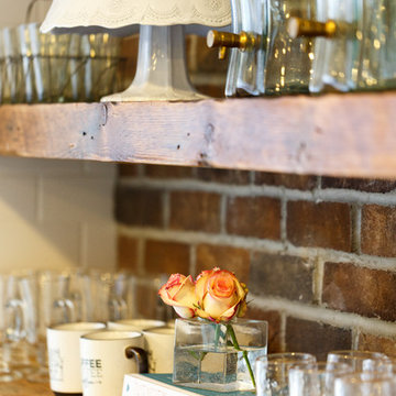 Beverage dispensers, cake stand, glassware and cookbooks on display.