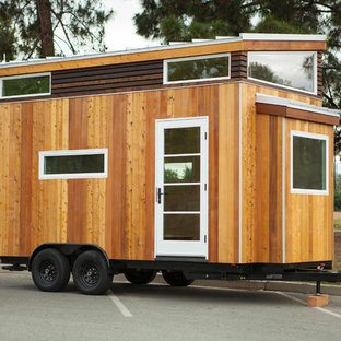Photo of a small modern home studio in Los Angeles with light hardwood flooring, no fireplace, a built-in desk and white walls.