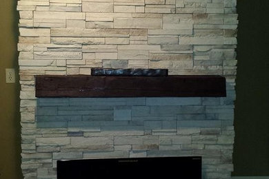 Mid-sized transitional enclosed light wood floor family room photo in Other with beige walls, a standard fireplace, a stone fireplace and no tv
