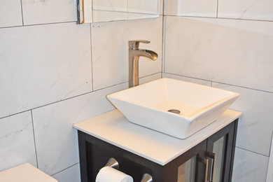 Small minimalist black and white tile and porcelain tile slate floor and black floor bathroom photo in New York with a one-piece toilet, a vessel sink, granite countertops and white countertops