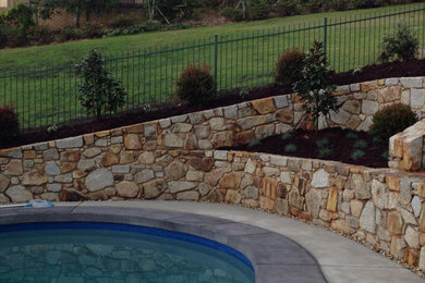 Inspiration for a large contemporary sloped full sun xeriscape in Other with a retaining wall.