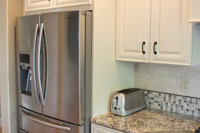 Inspiration for a contemporary l-shaped eat-in kitchen remodel in San Francisco with a farmhouse sink, white cabinets, granite countertops, beige backsplash and stainless steel appliances