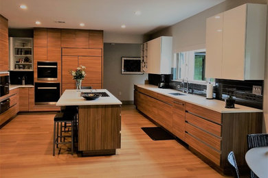 Open concept kitchen - large contemporary u-shaped medium tone wood floor open concept kitchen idea in Las Vegas with laminate countertops, black backsplash, glass tile backsplash, stainless steel appliances, an island and brown countertops