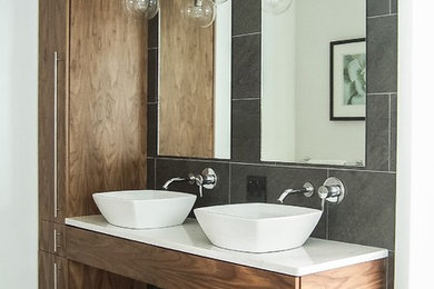 Photo of a mid-sized contemporary master bathroom in Grand Rapids with gray tile, quartzite benchtops, flat-panel cabinets, medium wood cabinets, ceramic tile, ceramic floors and a vessel sink.