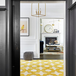 Exempel på en mellanstor klassisk hall, med svarta väggar och mellanmörkt trägolv