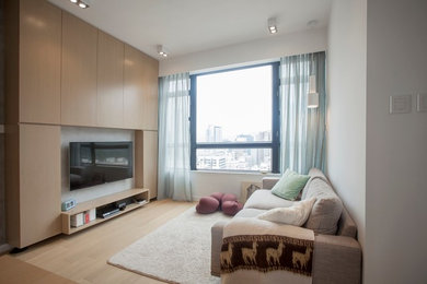 Mid-sized minimalist enclosed medium tone wood floor living room photo in Hong Kong with gray walls and a wall-mounted tv