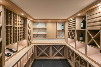 Cette image montre une grande cave à vin design avec un sol en carrelage de céramique, un présentoir et un sol gris.