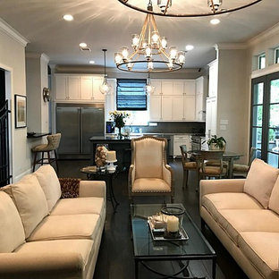 Modelo de salón para visitas abierto, mediterráneo, grande, con paredes beige, suelo laminado, televisor retractable y suelo marrón