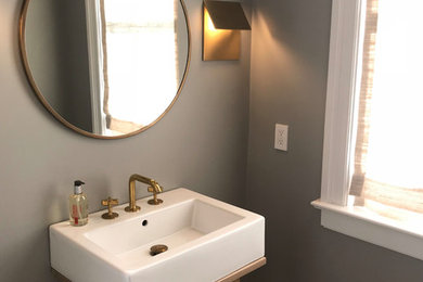 This is an example of a small contemporary powder room in New York with open cabinets, light wood cabinets, grey walls, mosaic tile floors, a console sink, solid surface benchtops, beige floor and white benchtops.