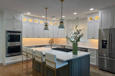 Inspiration for a mid-sized timeless l-shaped eat-in kitchen remodel in Other with an undermount sink, raised-panel cabinets, white cabinets, quartz countertops, white backsplash, stainless steel appliances, an island and white countertops