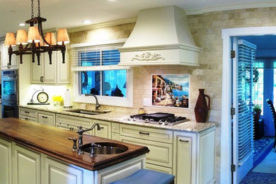 Example of a huge tuscan galley porcelain tile eat-in kitchen design in Baltimore with an undermount sink, raised-panel cabinets, beige cabinets, granite countertops, beige backsplash, stone tile backsplash, stainless steel appliances and an island