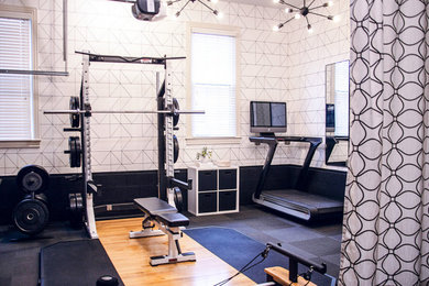 This is an example of a mid-sized modern home weight room in Nashville with black floor.