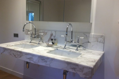 他の地域にあるトランジショナルスタイルのおしゃれな浴室 (大理石の洗面台) の写真