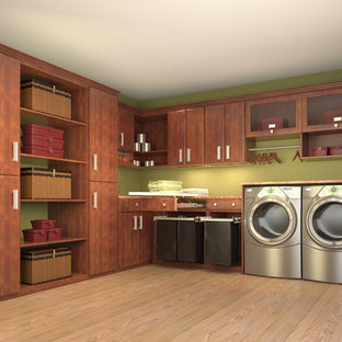 ロサンゼルスの中サイズのコンテンポラリースタイルのおしゃれなランドリールーム (フラットパネル扉のキャビネット、中間色木目調キャビネット、緑の壁、淡色無垢フローリング、左右配置の洗濯機・乾燥機) の写真