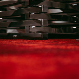 This is an example of a large modern home office and library in Edmonton with grey walls, ceramic flooring and a hanging fireplace.