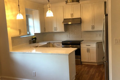 Transitional kitchen photo in New York with shaker cabinets, white cabinets, white backsplash and subway tile backsplash