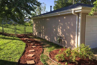 This is an example of a mid-sized traditional partial sun side yard concrete paver garden path in Other.