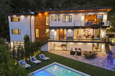 Expansive modern three-storey white house exterior in Los Angeles with mixed siding and a flat roof.