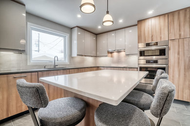 Example of a mid-sized trendy l-shaped porcelain tile and gray floor kitchen design in Ottawa with a double-bowl sink, flat-panel cabinets, light wood cabinets, quartz countertops, multicolored backsplash, porcelain backsplash, stainless steel appliances, an island and multicolored countertops