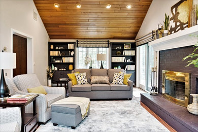 Mid-sized contemporary enclosed family room in Boston with grey walls, medium hardwood floors, a standard fireplace, a wood fireplace surround and brown floor.