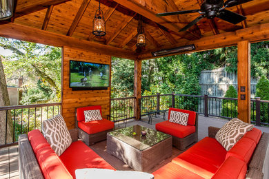 Example of a mid-sized mountain style backyard patio design in DC Metro with decking and a gazebo